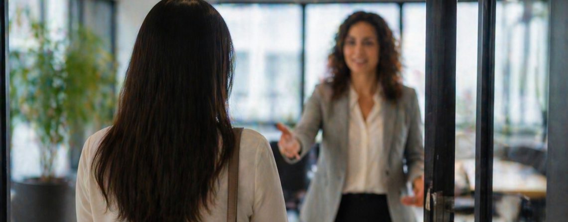 Manager extending a welcoming hand toward an employee returning to the office, illustrating a reversed dismissal.