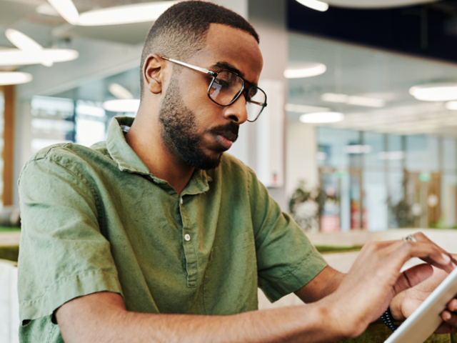 A man using an online severance pay calculator on his phone to estimate his termination entitlement in Ontario