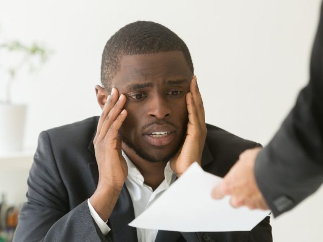 Distressed employee receiving termination papers from a manager, pay in lieu of notice in British Columbia explained.