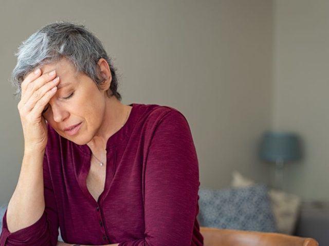 Distressed woman at home reflecting on what BC employees should know before responding to their employer in workplace disputes.