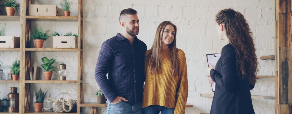 Real estate agent meeting with a couple in a bright office, representing the BC real estate workplace context of the City Realty case.