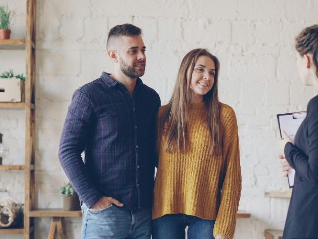 Real estate agent meeting with a couple in a bright office, representing the BC real estate workplace context of the City Realty case.