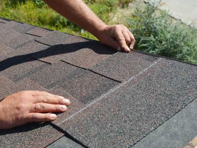 Roofer installing shingles on a residential roof, representing the roofing industry context of the Baker v. Firon Roofing case.