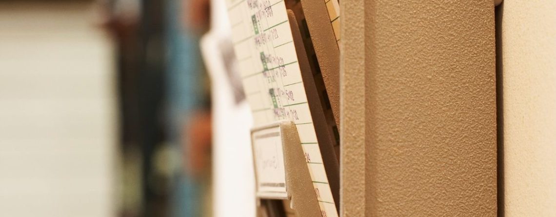 Rows of old employee time cards in a storage rack, illustrating the swipe-and-go termination practices at Bell Canada.