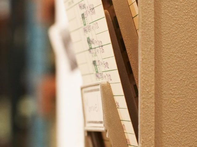 Rows of old employee time cards in a storage rack, illustrating the swipe-and-go termination practices at Bell Canada.
