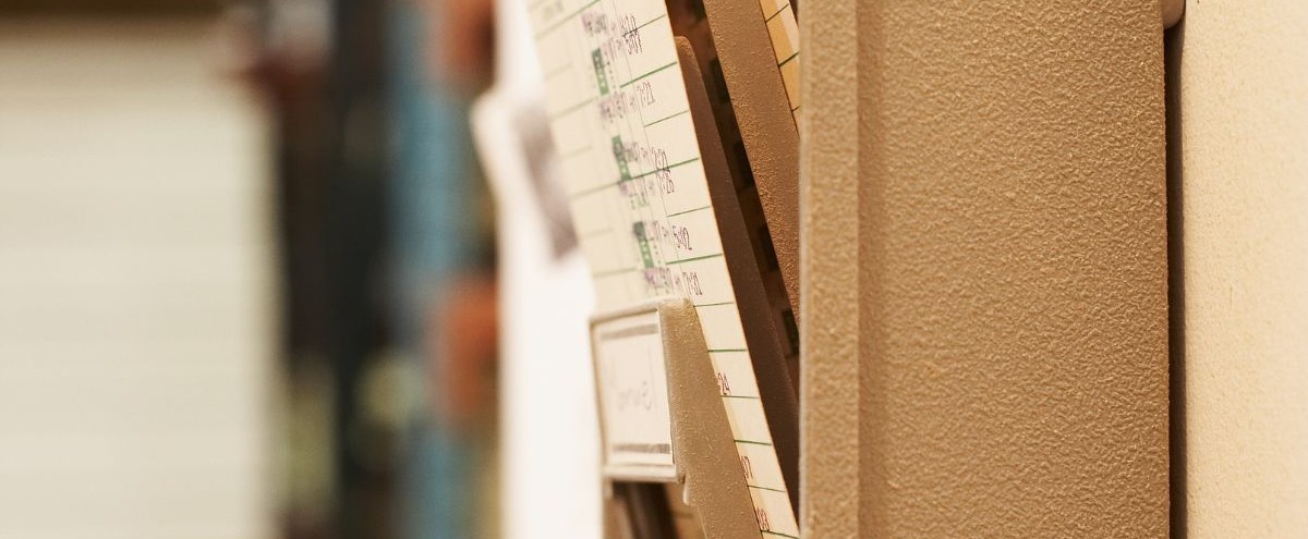 Rows of old employee time cards in a storage rack, illustrating the swipe-and-go termination practices at Bell Canada.