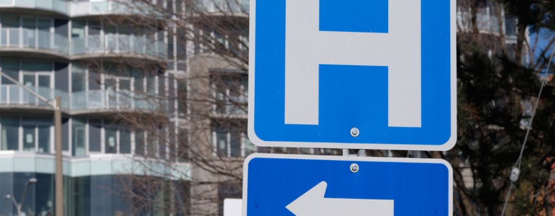 Road sign pointing toward a hospital, illustrating the 2026 Ottawa healthcare layoffs