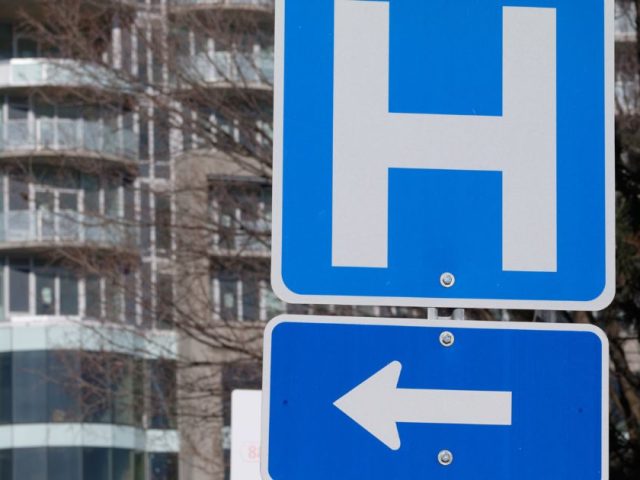 Road sign pointing toward a hospital, illustrating the 2026 Ottawa healthcare layoffs