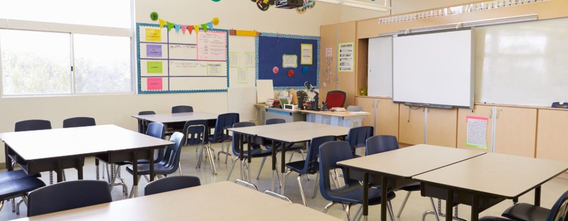 An empty classroom with rows of desks, representing a school workplace.