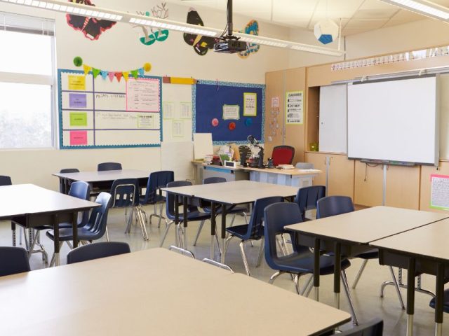 An empty classroom with rows of desks, representing a school workplace.