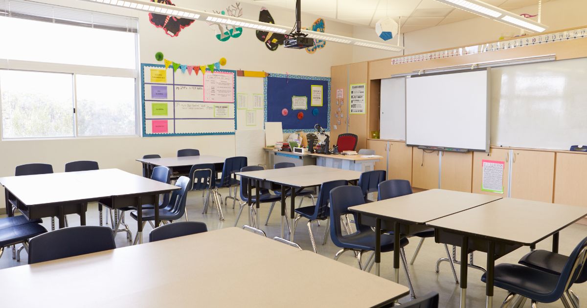An empty classroom with rows of desks, representing a school workplace.