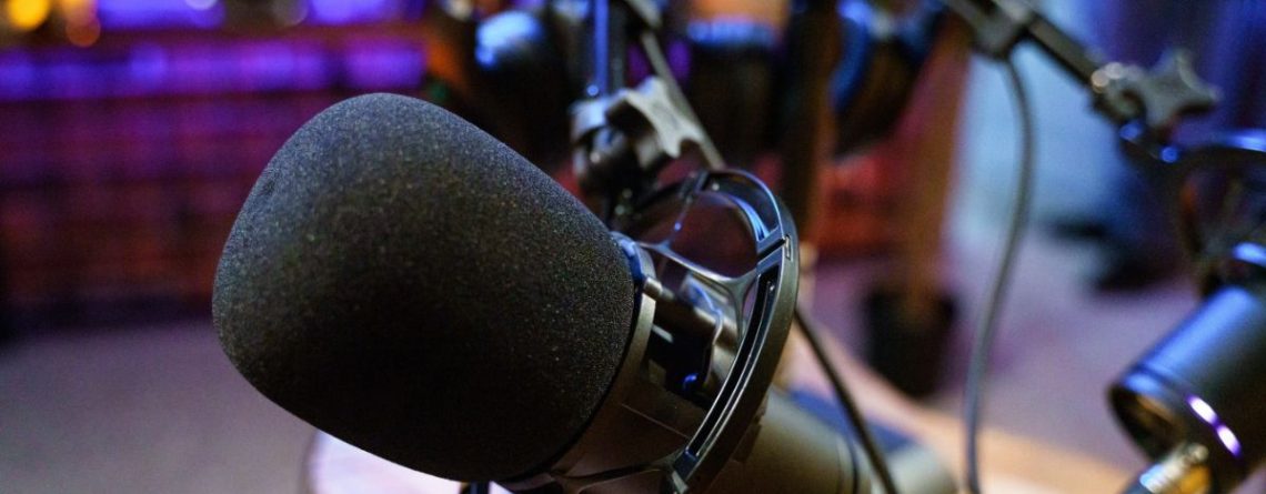 A close-up of a microphone in an empty radio broadcast studio