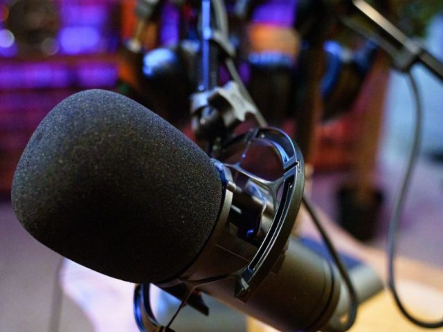 A close-up of a microphone in an empty radio broadcast studio