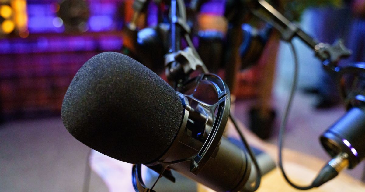 A close-up of a microphone in an empty radio broadcast studio